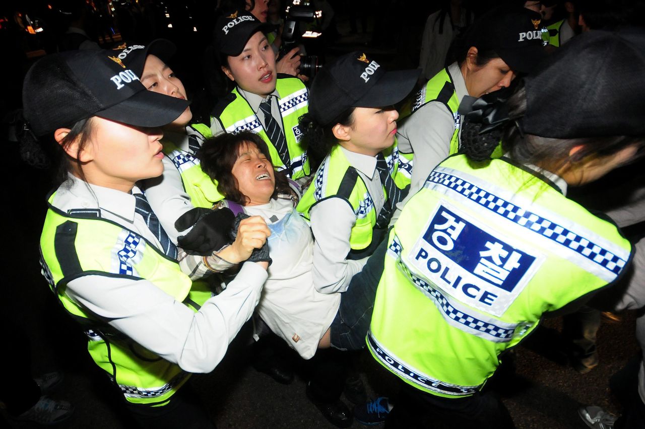 Police in Seoul detain a protester during a march Saturday, May 17, for victims of the Sewol.
