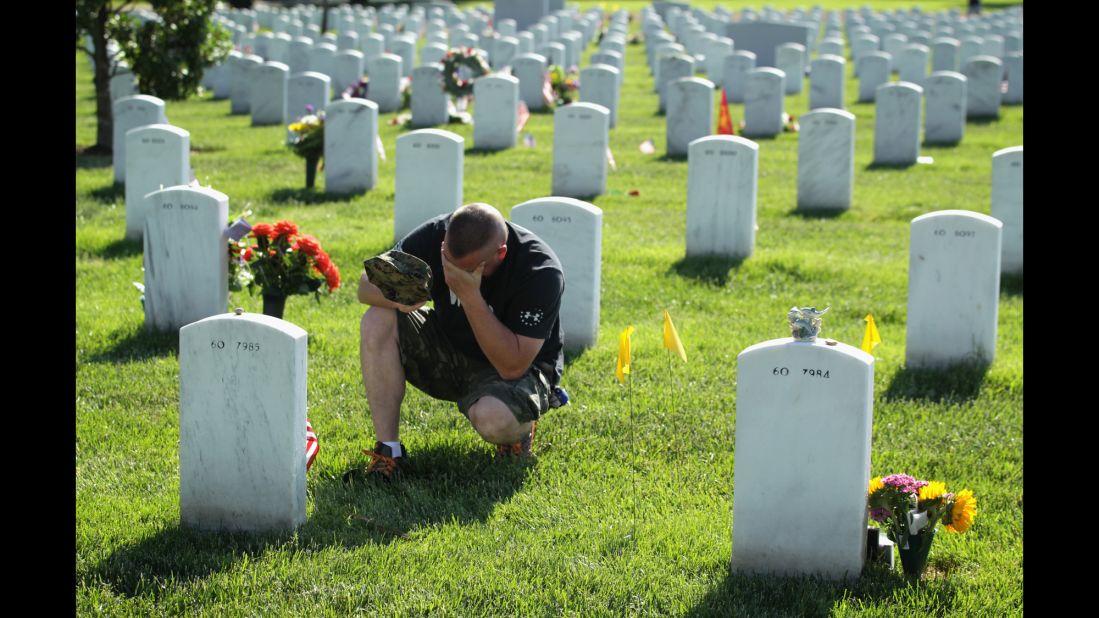 Mike Sunderhaus of Bel Air, Maryland, becomes emotional Sunday, May 25, 2014, as he visits the grave of his friend, Marine Lance Cpl. Jeremiah E. Savage, at Arlington National Cemetery. Savage was killed in 2004 during Operation Iraqi Freedom.