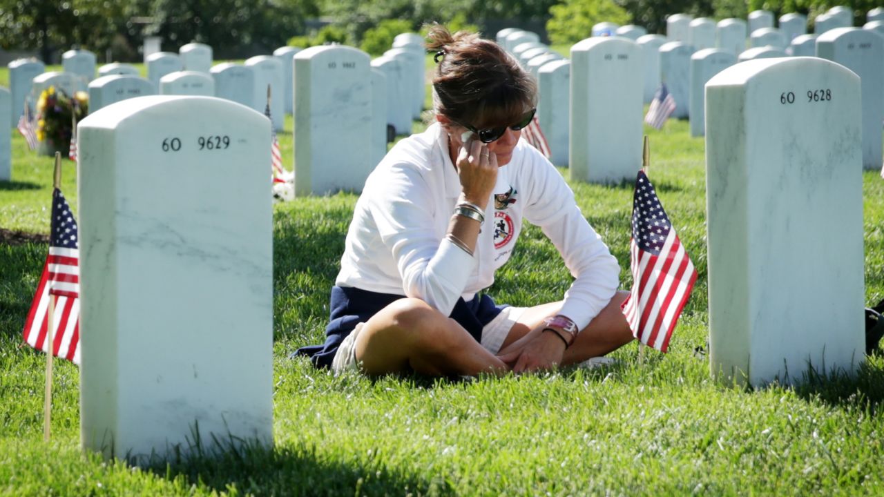 Sarah Greene wipes tears as she visits the grave of her husband, Marine Lt. Col. David S. Greene, at Arlington National Cemetery on May 25, 2014. He was killed in Iraq in 2004.