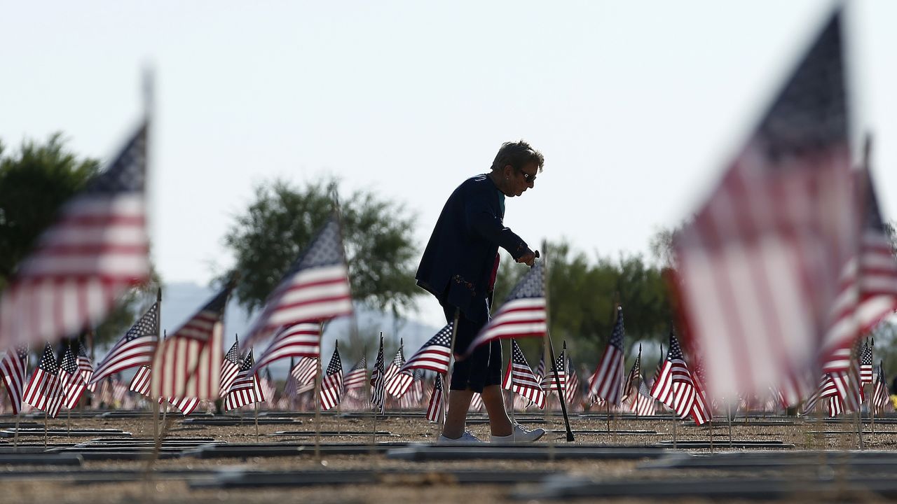 After visiting the grave of her husband, World War II veteran William Murphy, Raymonde Murphy walks past graves at the National Memorial Cemetery of Arizona in Phoenix on May 26, 2014.