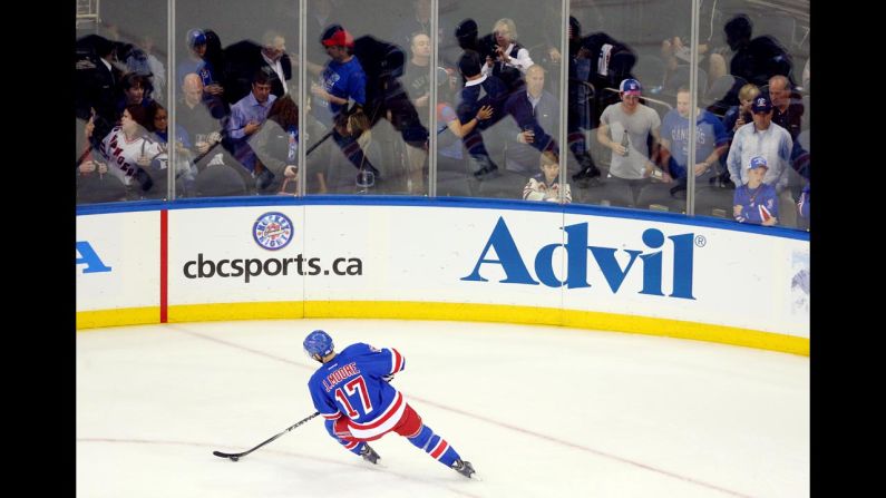 Multiple reflections of New York Rangers defenseman John Moore are seen on the boards as he warms up for Game 4 of the NHL's Eastern Conference finals Sunday, May 25, in New York. The Rangers defeated Montreal in overtime to take a commanding 3-1 lead in the best-of-seven series.