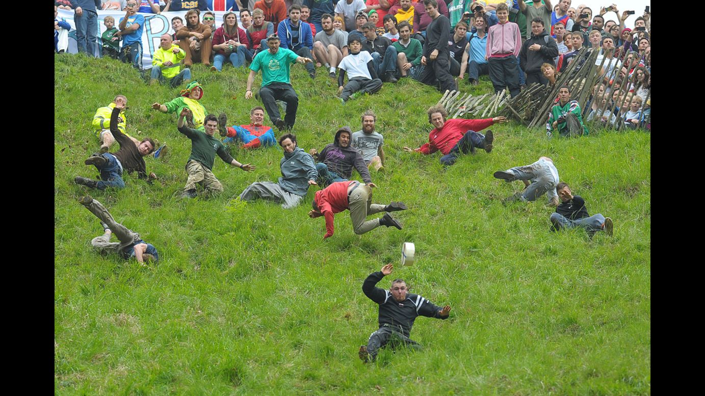 People compete Monday, May 26, in the annual cheese-rolling races at Cooper's Hill in Gloucestershire, England. In the races, runners chase Double Gloucester cheese wheels down an extremely steep hill. The first person over the finish line in each race wins the cheese.