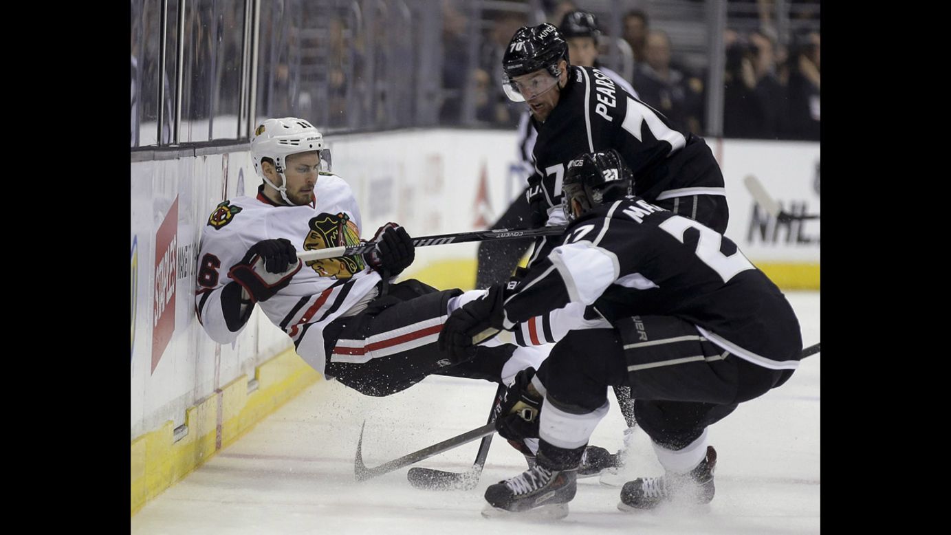 Chicago's Marcus Kruger, left, is checked by Los Angeles' Alec Martinez and Tanner Pearson during Game 3 of the NHL's Western Conference finals on Saturday, May 24. The Kings won 4-3 to take a 2-1 series lead.