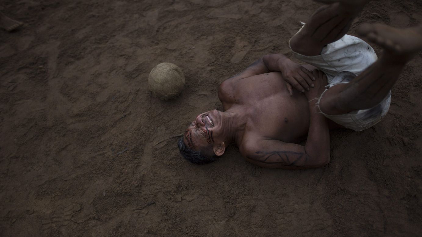 A man reacts Saturday, May 24, after being hit by the ball during a soccer game in the Tatuyo indigenous community near Manaus, Brazil. Manaus, in the Amazon rainforest, is one of the host cities for the upcoming FIFA World Cup.