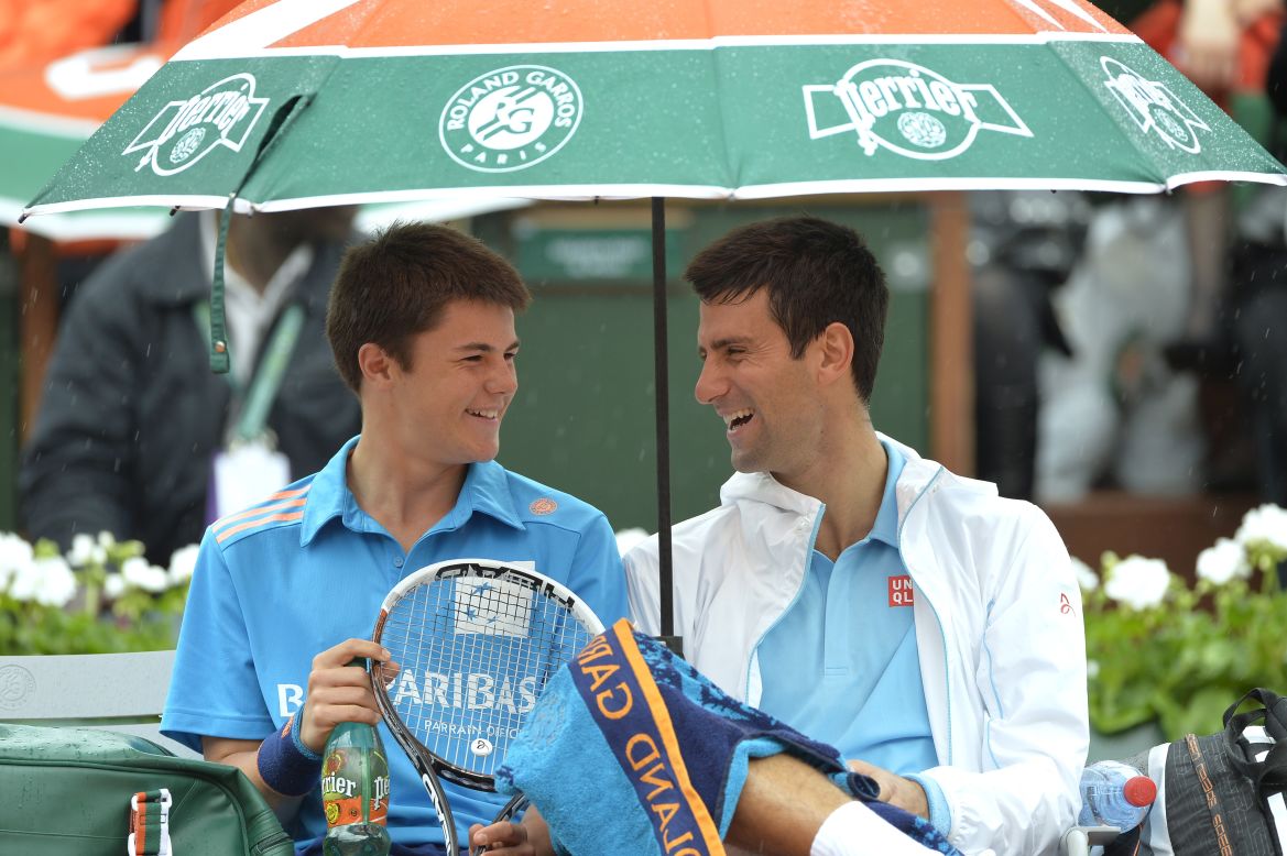 Novak Djokovic shares a moment with a ball boy during a break in play at the French Open in Paris. He went on to beat <br />Joao Sousa in straight sets in a match interrupted by the rain.