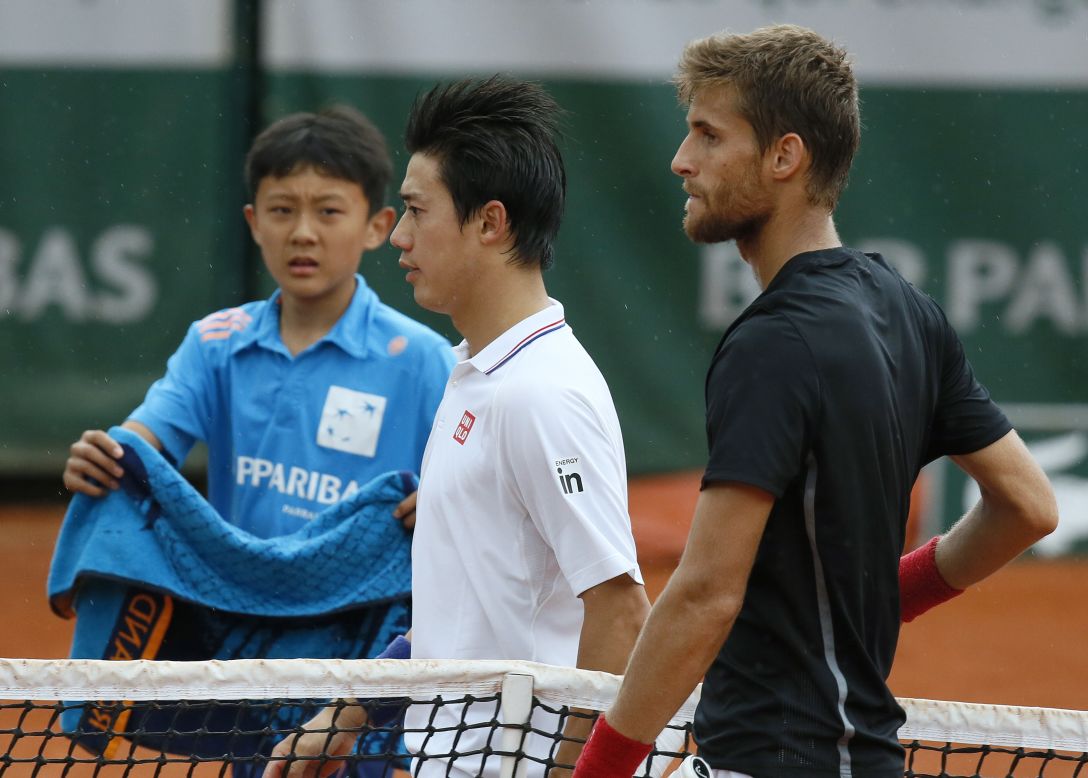 Kei Nishikori of Japan shakes hands with Martin Kluzan (right) after the Slovakian beat him in straight sets in Paris.