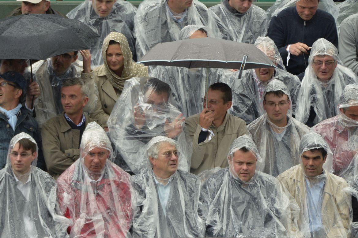 Rainwear was the order of the second day of the French Open as persistent showers caused delays to the action.