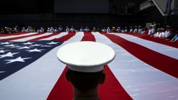 Members of the military unfurl an American flag during a wreath laying ceremony at the Intrepid Sea, Air & Space Museum in New York on Monday, May 26.