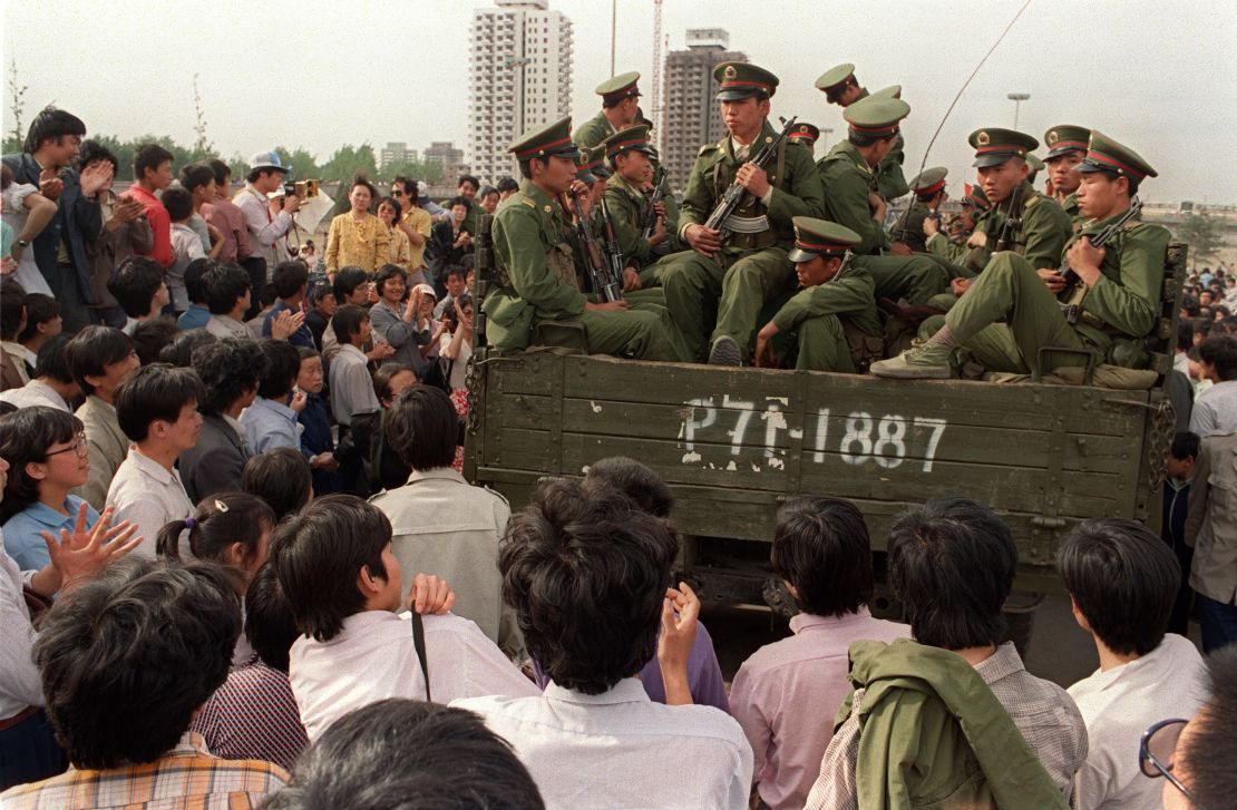 Pro-democracy demonstrators surround a truck filled of People's Liberation Army (PLA) soldiers on 20 May 1989 in Beijing on their way to Tiananmen Square.