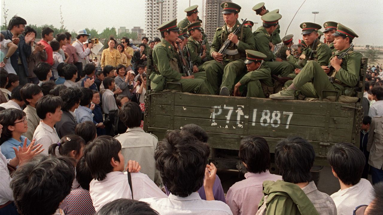 Pro-democracy demonstrators surround a truck filled of People's Liberation Army (PLA) soldiers on 20 May 1989 in Beijing on their way to Tiananmen Square.