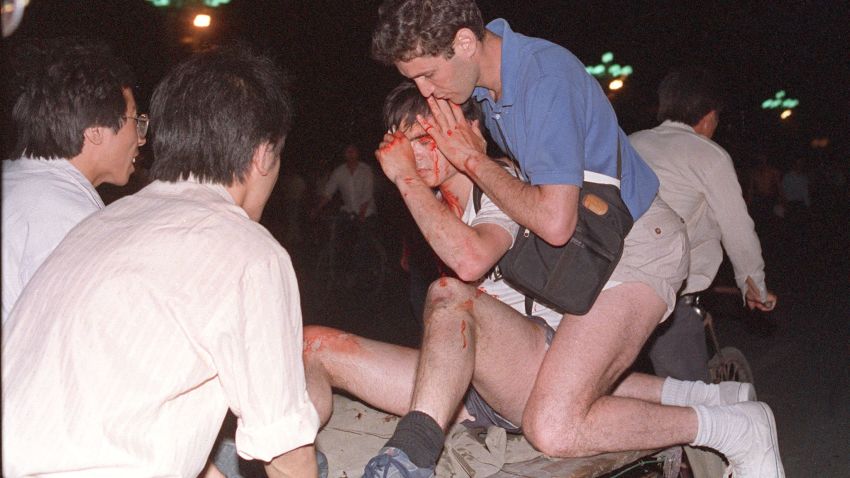 BEIJING, CHINA: Taken care by others, an unidentified foreign journalist (2nd-r) is carried out from the clash site between the army and students 04 June 1989 near Tiananmen Square. On the night of 03 and 04 June 1989, Tiananmen Square sheltered the last pro-democracy supporters. Chinese troops forcibly marched on the square to end a weeks-long occupation by student protestors, using lethal force to remove opposition it encountered along the way. Hundreds of demonstrators were killed in the crackdown as tanks rolled into the environs of the square. (Photo credit should read THOMAS CHENG/AFP/Getty Images)