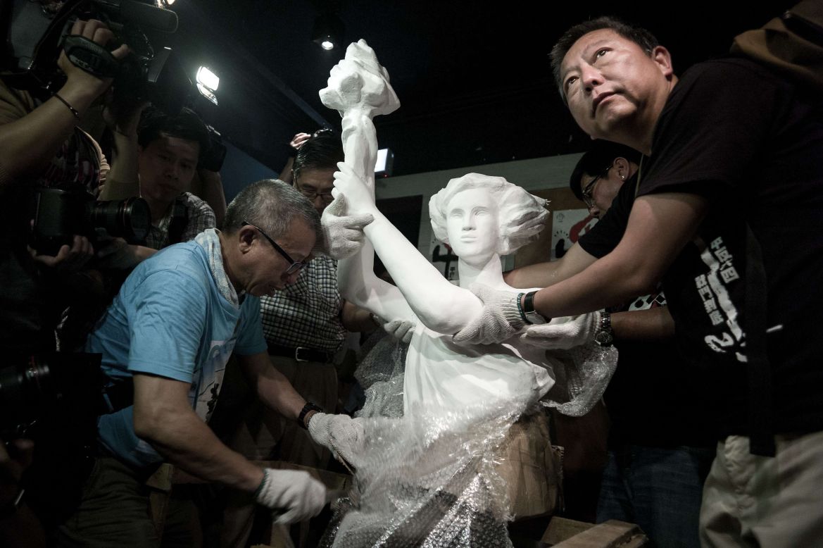 Today, Hong Kong is the only Chinese territory where commemoration of the June 4 crackdown is allowed. Here, pro-democracy legislator Lee Cheuk-yan (left) unwraps a replica of the Goddess of Democracy at Hong Kong's June 4 Museum that opened on April 24, 2014.
