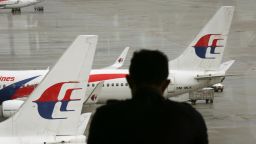 A visitor looks out from the viewing gallery as Malaysia Airlines aircraft sit on the tarmac at the Kuala Lumpur International Airport (KLIA) in Sepang, Malaysia, Tuesday, May 27, 2014.