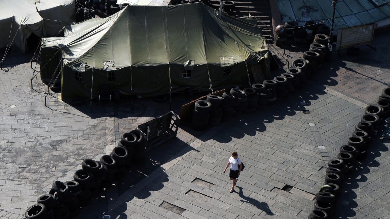 A woman walks May 26 near barricades built by protesters in Kiev's Independence Square. Vitali Klitschko, Kiev's future mayor and a former boxing champion, promised to dismantle the iconic protest encampment that helped oust Yanukovych but now clogs traffic and draws public complaints.