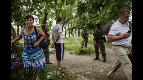 Men stand next to pro-Russian militants as a woman runs away during clashes near the airport on May 26.