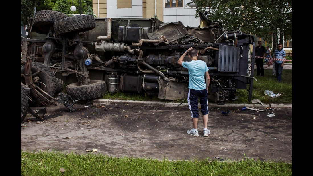 A man stands in front of a truck that was bombed by Ukrainian soldiers during clashes with armed rebels Tuesday, May 27, in Donetsk.