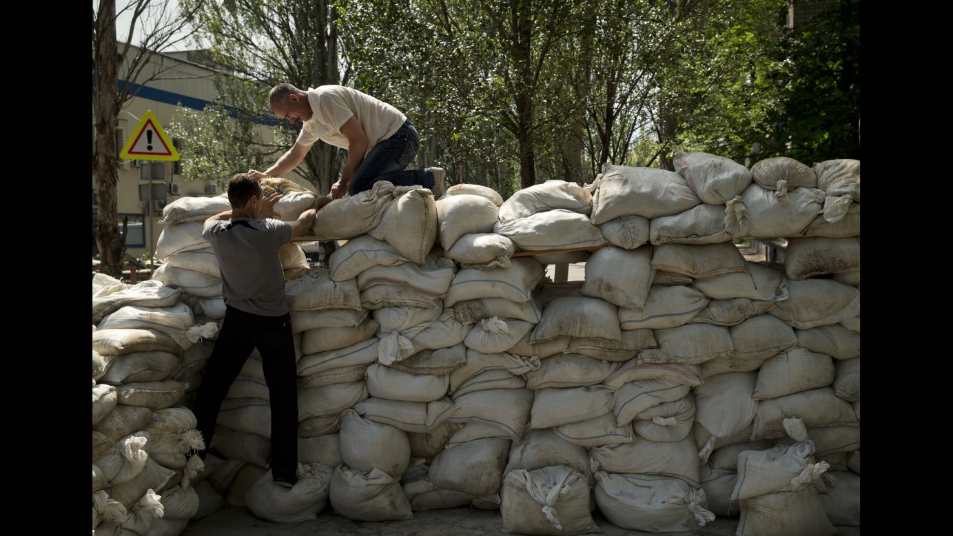 People pile up sandbags to set up a shooting position on the road leading from the Donetsk airport on May 27. 