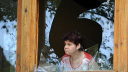 A woman looks out from a broken window in a bakery after a night of combat between pro-Russia separatists with Ukrainian troops in the eastern Ukrainian city of Slavyansk on May 27, 2014.