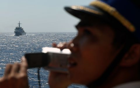 This picture taken from a Vietnam Coast Guard ship shows a Vietnamese Coast Guard officer taking picture of an approaching China Coast Guard ship.