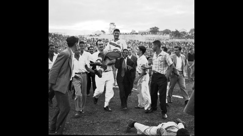 American forward Joe Gaetjens is carried off the field by fans after the United States upset England 1-0 in a first-round match in Belo Horizonte, Brazil. Gaetjens scored the winning goal, which is still considered one of the most important goals in American soccer history.