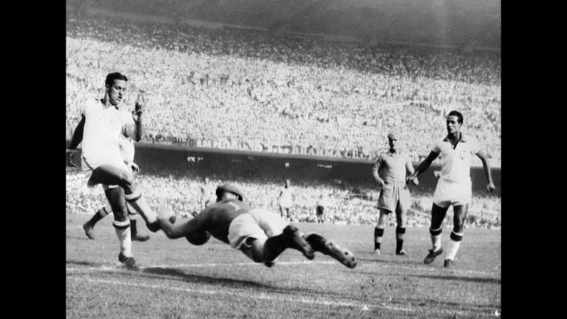 Swedish goalkeeper Kalle Svensson dives to block the ball in front of Brazilian forward Ademir during a final-round match in Rio de Janeiro. Ademir, who scored four goals in the 7-1 thrashing, would go on to finish as the tournament's leading scorer with eight goals.