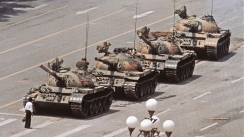 Um homem solitário com sacolas de compras interrompe temporariamente um ataque de tanque chinês após uma repressão sangrenta com manifestantes, Pequim, 5 de junho de 1989.