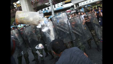 A protester throws a garbage can at a line of Thai soldiers during an anti-coup demonstration in Bangkok on May 28.