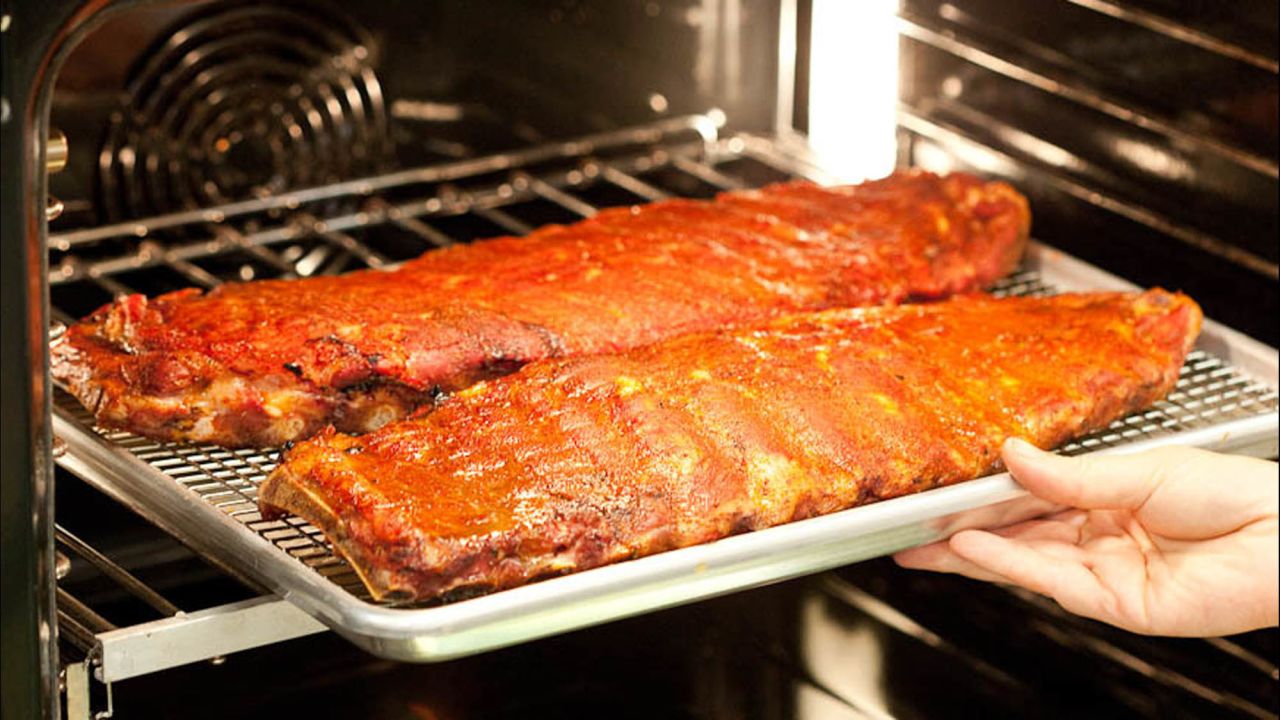We then transfer the ribs to a low oven to cook 2 to 3 hours more. Water added to the baking sheet helps keep the meat moist.