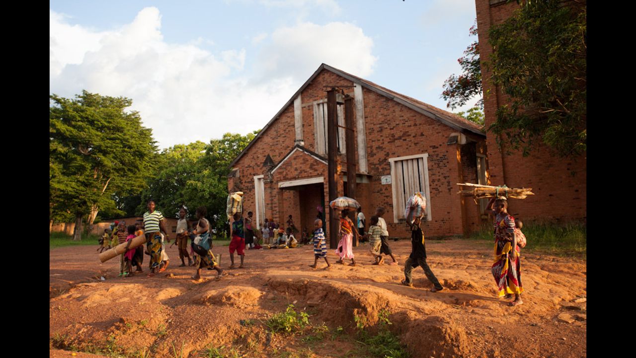 Families pass the cathedral in Bambari and look for safety following the clashes between Muslim youths and peacekeepers. For three days, the two sides fought for control of the one bridge into town. 