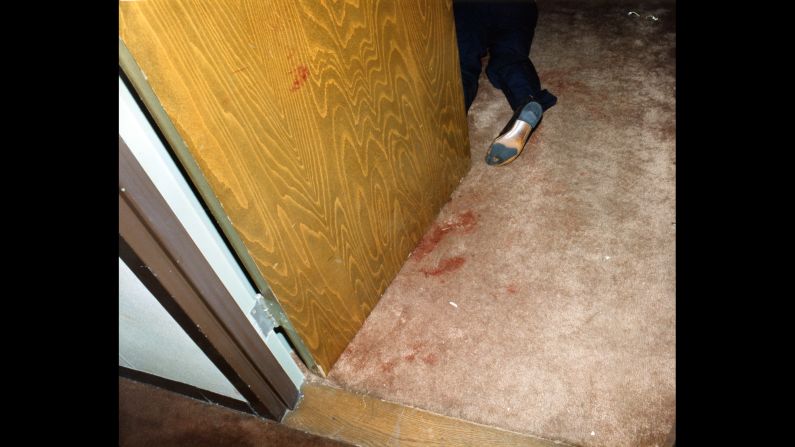 On October 16, 1986 police found the Moo Youngs' bloody bodies in Room 1215 at Miami's Dupont Plaza Hotel. This police evidence photo shows one of the bodies in a doorway. 
