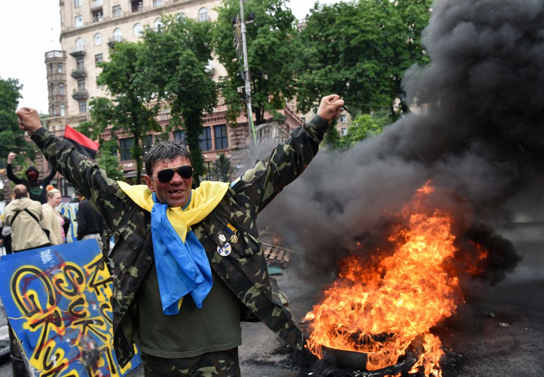 A protester from Kiev's Independence Square gestures May 31 as fellow protesters burn tires to protect their barricades from being dismantled by communal services.