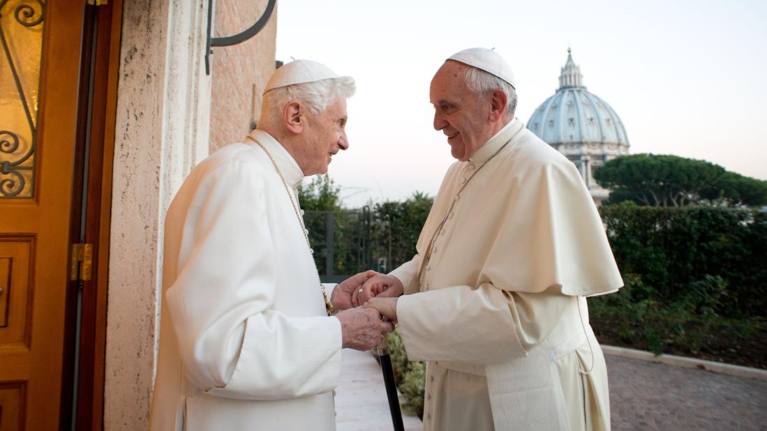 Pope Emeritus Benedict XVI, left, greets his successor, Pope Francis, in December 2013. Earlier in the year, Benedict became the first pope to resign in nearly six centuries.