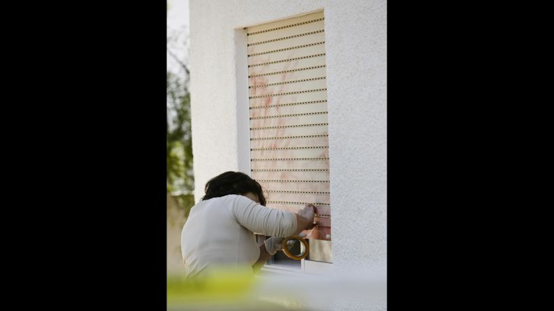 In this photo from 2007, a Portuguese police officer searches for evidence on the window that leads to the room where Madeleine was sleeping. 