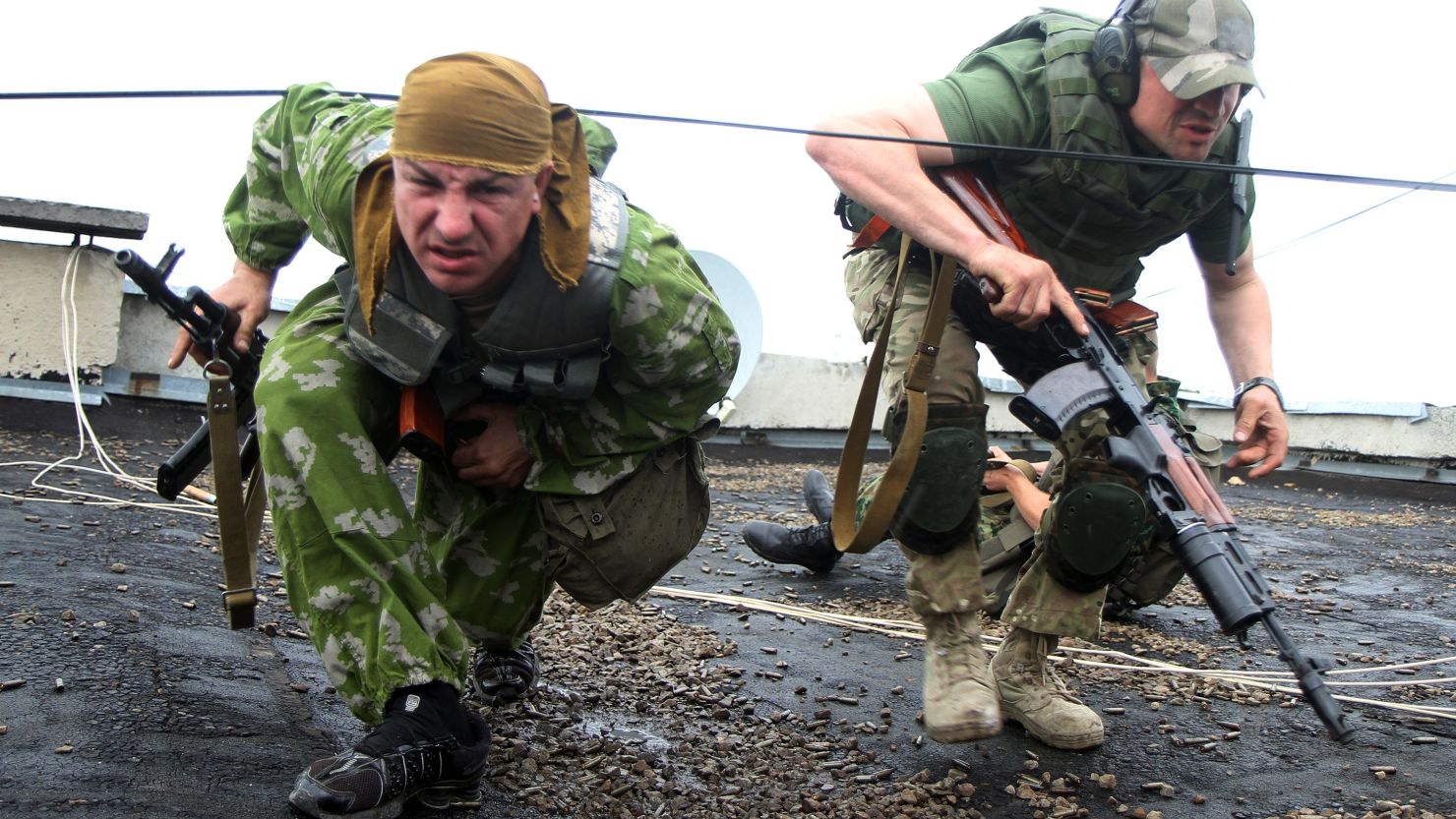 Pro-Russian militants prepare to shoot from a roof of a residential building at border guards in Luhansk on Monday.