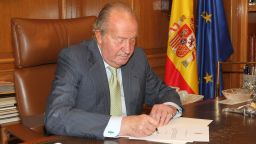 In this handout image provided by the Spanish Royal Palace, King Juan Carlos of Spain signs papers to confirm his abdication on June 02, 2014 in Madrid, Spain