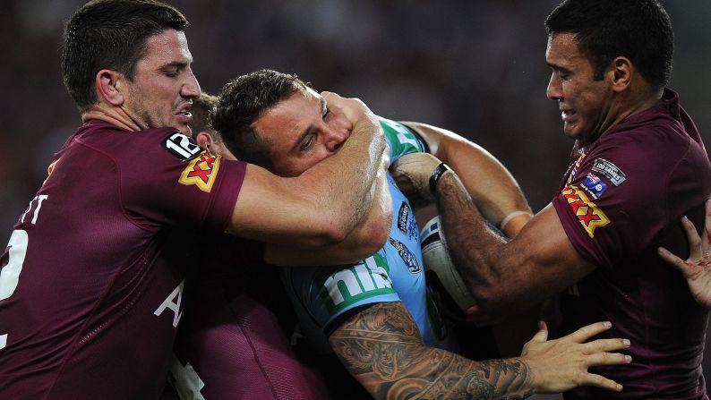 Anthony Watmough of the New South Wales Blues is tackled by two players of the Queensland Maroons during Game 1 of the State of Origin series, which was played Wednesday, May 28, in Brisbane, Australia. The Blues won the rugby league game 12-8, and the two teams will continue the best-of-three series on June 18.