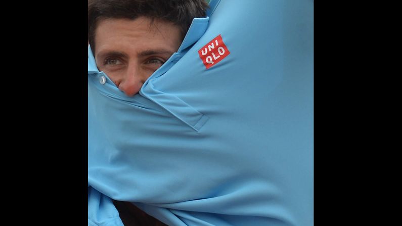 Tennis player Novak Djokovic appears lost in his shirt Friday, May 30, during a match against Marin Cilic in the third round of the French Open. Djokovic advanced in four sets.