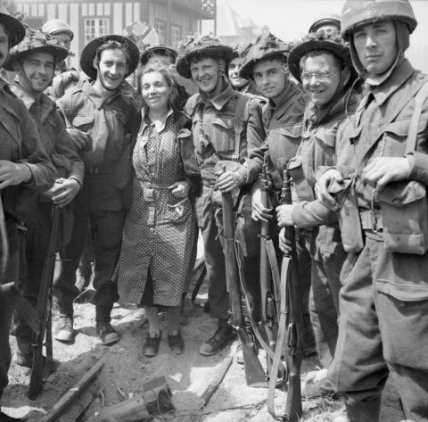 British troops pose for a photograph with a French woman in La Breche d'Hermanville.