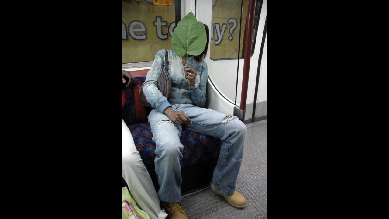 The photographs have revealed how fashion has changed over the decades. Here, a woman hides behind a leaf as her photograph is taken in the late 1990s. "She let me take several pictures with the leaf not in front of her face, then did that just for fun, really," Mazzer says. <br />