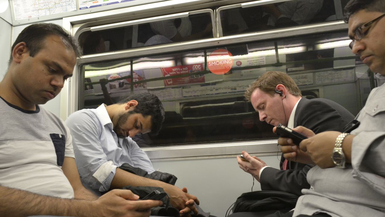 Mazzer says photographing the underground has shown how people have changed from reading newspapers and smoking, to becoming attached to their iPads and smartphones, like these men from 2013.