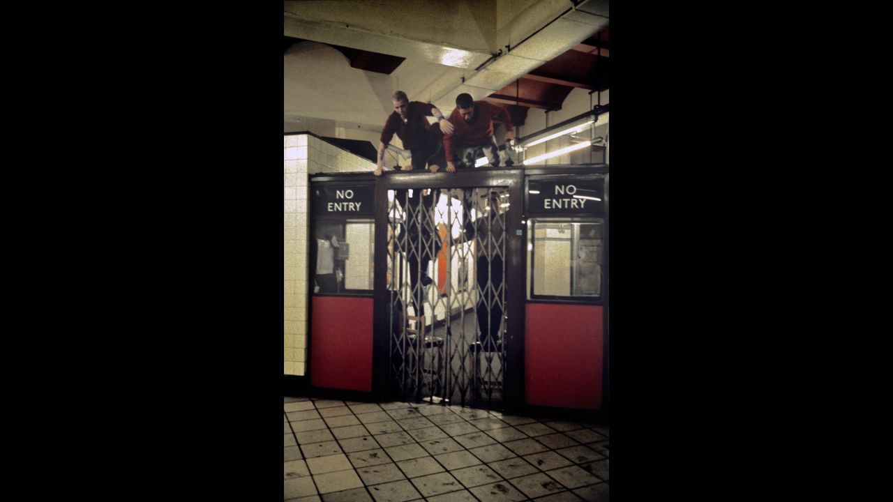 Mazzer's images have captured many late night scenes, as he traveled to and from his work at a cinema. In this one, boys clamber up and jump over a closed gate. Mazzer notes how they'd taken the little stools used by ticket collectors to assist their escape. "There's nothing like that you can climb over anymore, it's all ticketed barriers," he says. 