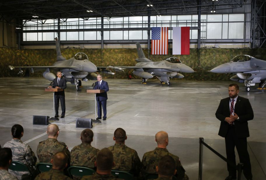 A Polish security official, right, stands watch as Obama and Komorowski make statements after meeting U.S. and Polish troops at an event in Warsaw on June 3. The main focus of Obama's Poland visit comes Wednesday, June 4, when he will give a speech  25 years after the nation's historic elections of 1989.