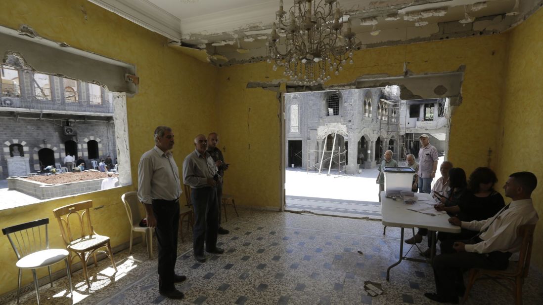 Syrians cast their votes in the damaged courtyard of the Umm al-Zunnar church in Homs on June 3.