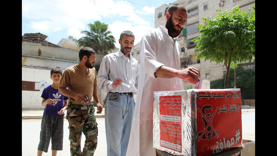 Men in Aleppo, Syria, pretend they are casting their votes June 3 during a mock election calling for al-Assad to the stripped of his Syrian nationality.