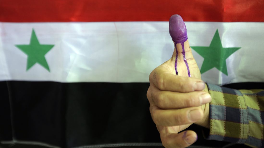 A Syrian man shows his ink-stained thumb after he voted in Homs on June 3. 