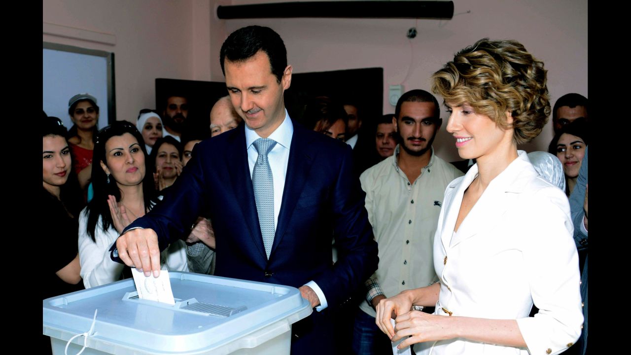 In this photo released by Syria's national news agency SANA, al-Assad casts his vote in Damascus on June 3. At right is his wife, first lady Asma al-Assad.