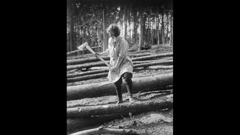 A member of the Women's Forestry Corps, part of the Women's Land Army in the United Kingdom, works circa 1916.