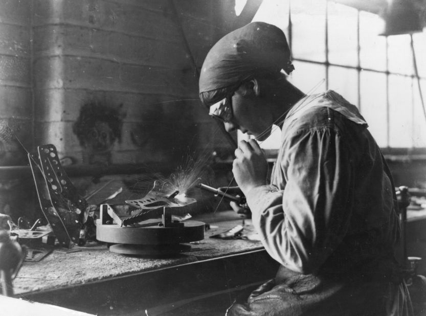 A female munitions worker welds at an armaments factory.