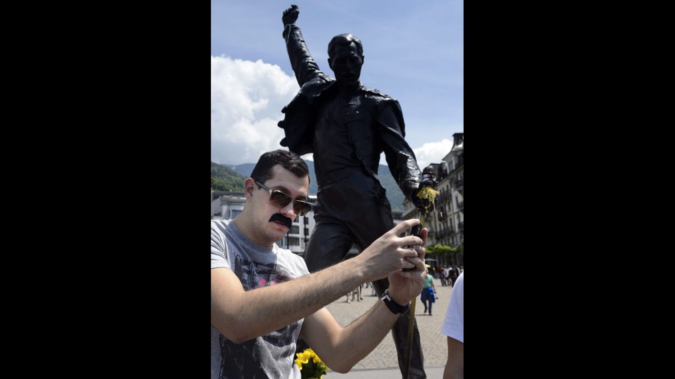 A man with a Freddie Mercury-like mustache snaps a selfie in front of a bronze statue of the late Queen singer Sunday, June 1, in Montreux, Switzerland. Mercury once lived in Montreux, which was hosting a Freddie for a Day festival to raise money for AIDS awareness. 