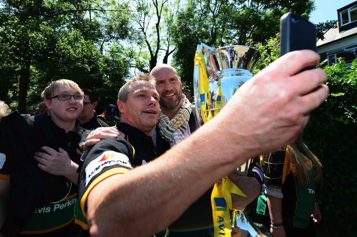 Retired rugby star Lawrence Dallaglio poses with fans as he carries the Aviva Premiership Trophy to London's Twickenham Stadium before the Premiership final between Saracens and Northampton Saints on Saturday, May 31. Northampton won the final 24-20.